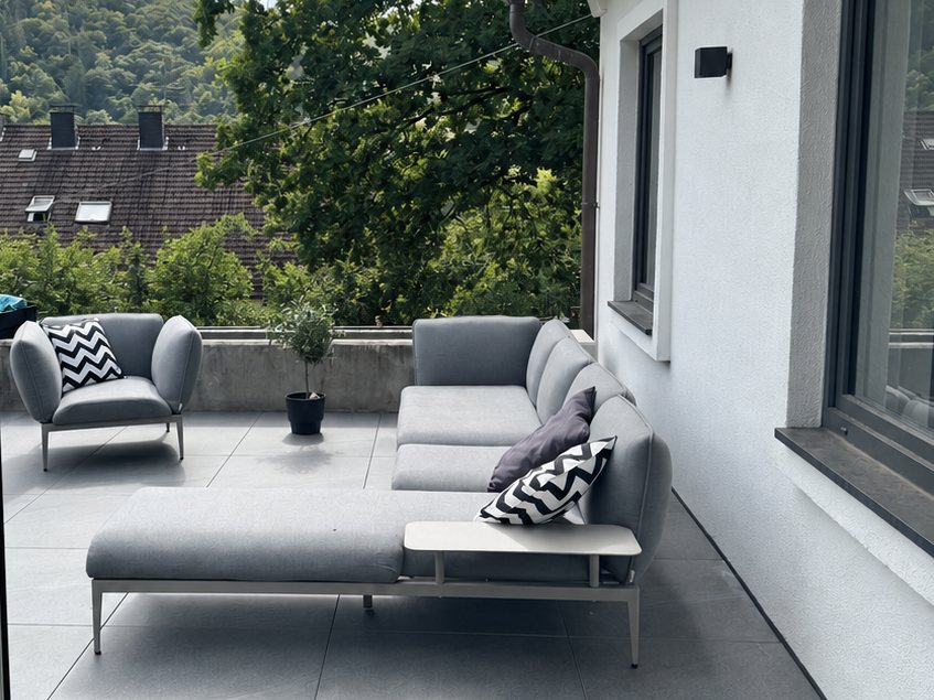 Terrasse mit gro&szlig;formatigem Feinsteinzeug und Lounge-M&ouml;beln, Blick ins Gr&uuml;ne